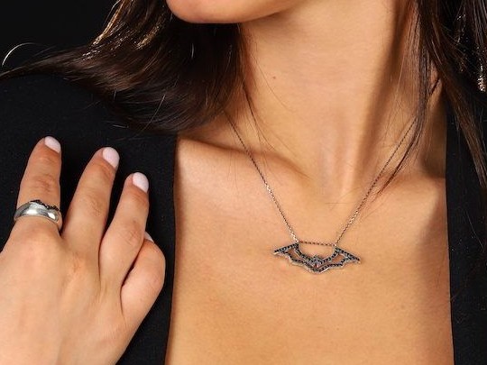דוגמנית עונדת שרשרת עטלף וטבעת מקו ICONYX JEWELRY