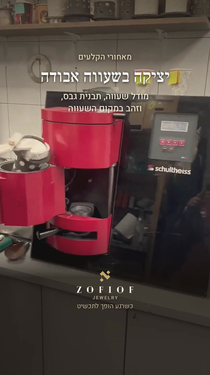 מאחורי הקלעים, יציקה בשעווה אבודה: מכונת יציקה אדומה בסדנה, עם הטקסט: מודל שעווה, תבנית גבס, וזהב במקום השעווה