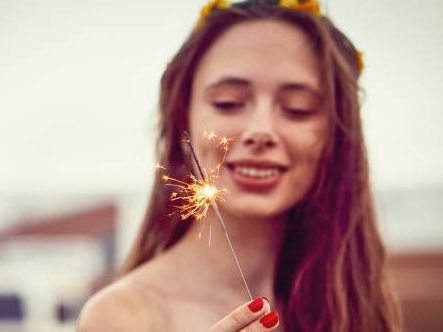 Young Beauty With Flowers In Her Hair Plays With Sparklers At Dusk.