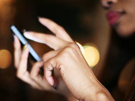 Close Up Of A Young Woman's Hand Typing Text Message On Her Smartphone.